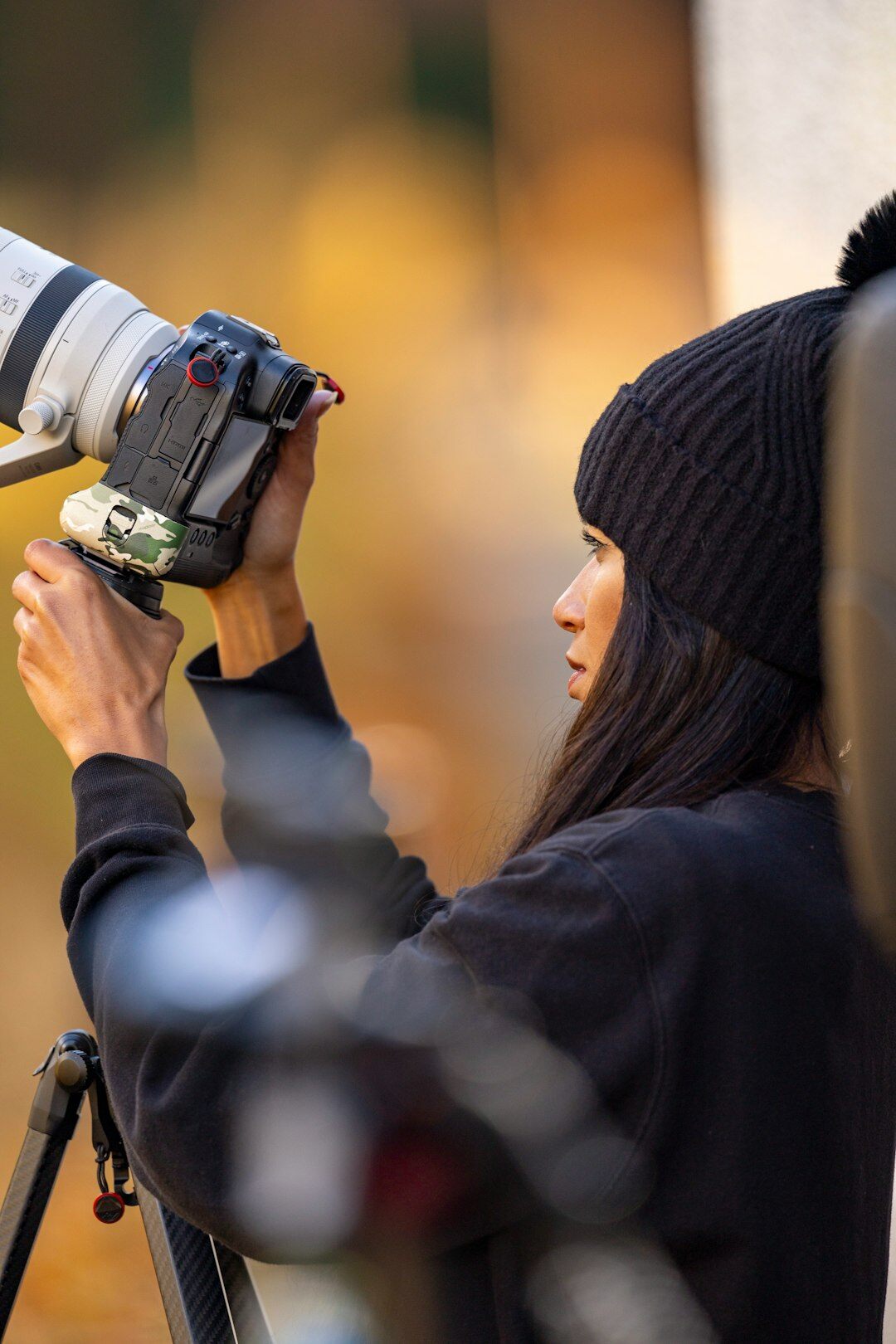 Female camera operator holding a professional broadcast camera on her shoulder outdoors